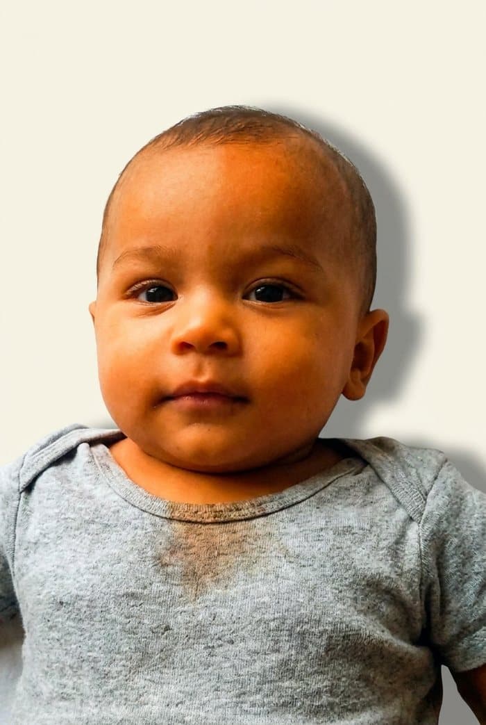 Baby photo with a shadow behind the head, warm filter, and oversized off-centre head — would be rejected